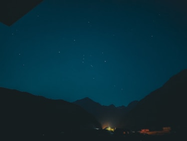 A peaceful meditation scene bathed in violet flame light under a starry night sky.