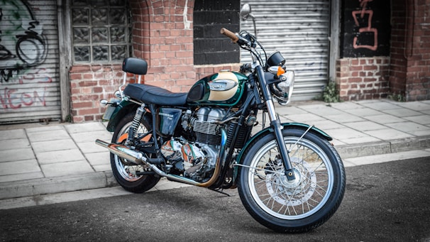 Motorcycle with shiny chrome details parked near a graffiti wall