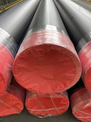 Stacks of construction materials and HDPE pipes organized in a large storage yard.