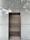 An elevator with metallic doors is set into a modern exterior with frosted glass panels. The reflection of surrounding trees and a building is faintly visible on the glass, giving a somewhat ethereal appearance.