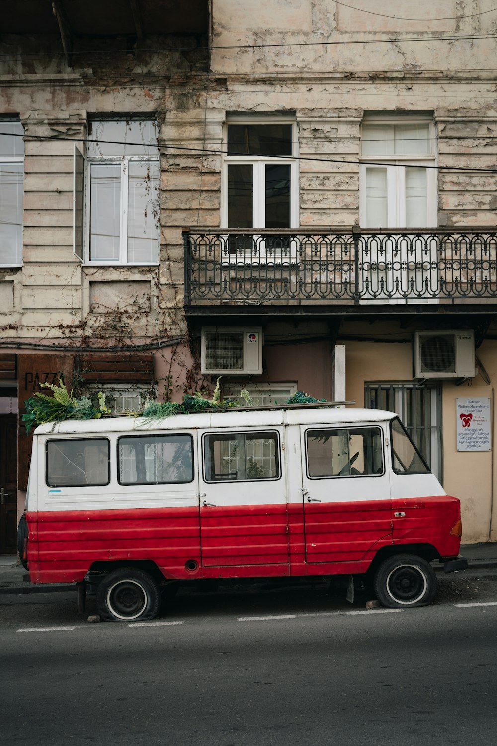a red and white van parked in front of a building