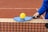 a person holding a tennis racket and a ball on a tennis court