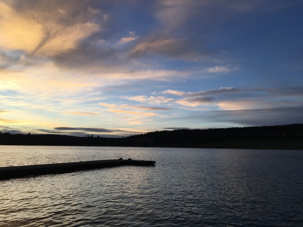 a body of water with a dock in the middle of it