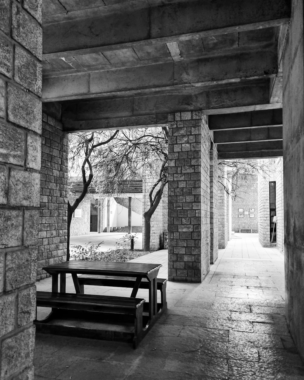 a black and white photo of a bench and table