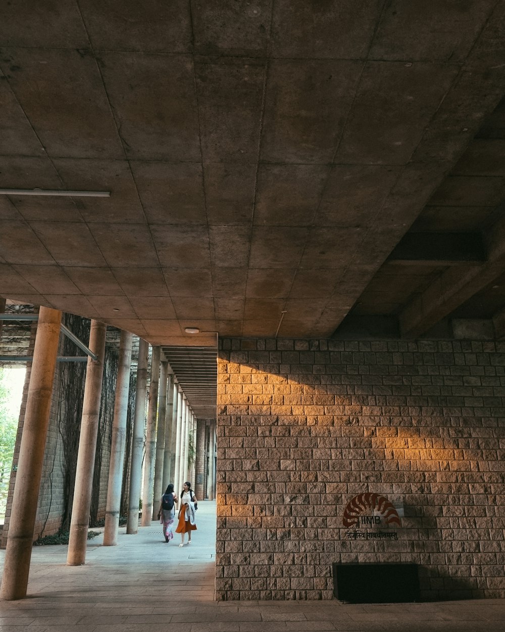 two people are walking under a bridge