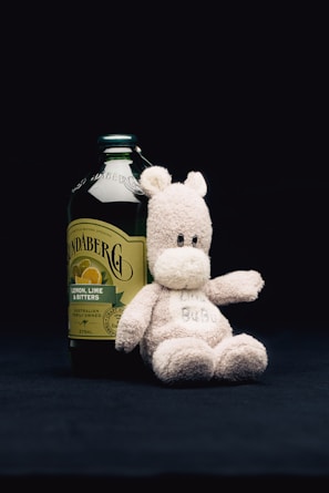 Close-up of the glass bottle of teddyclub ayurvedic bear on a wooden table with soft natural light highlighting the gold accents.