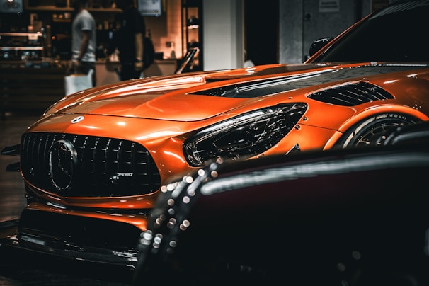 Front view of a sleek orange sedan parked in a modern showroom.