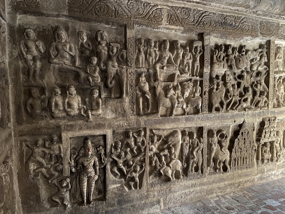 a stone wall with a bunch of carvings on it