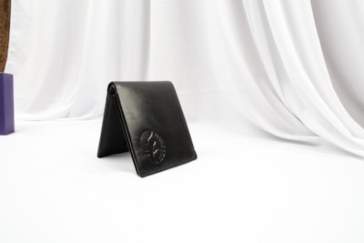 Sleek black leather cardholder resting on a marble surface with soft natural light