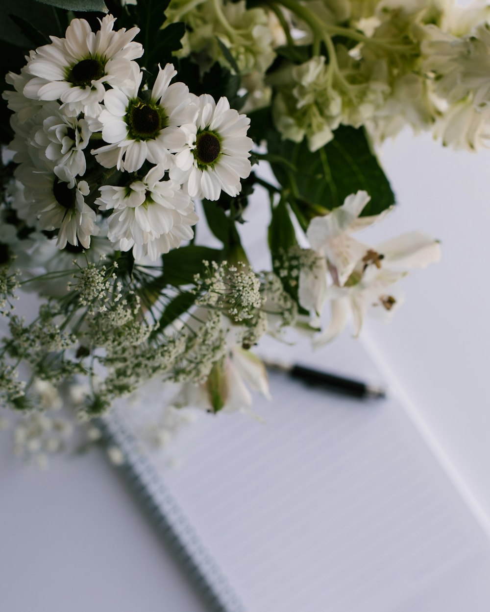 a bouquet of flowers sitting on top of a notebook
