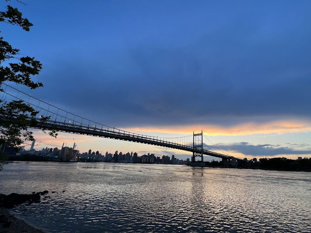 a bridge over a body of water with a city in the background