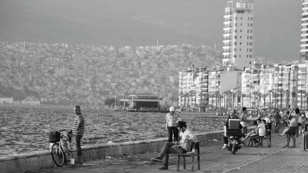 a black and white photo of people on a pier