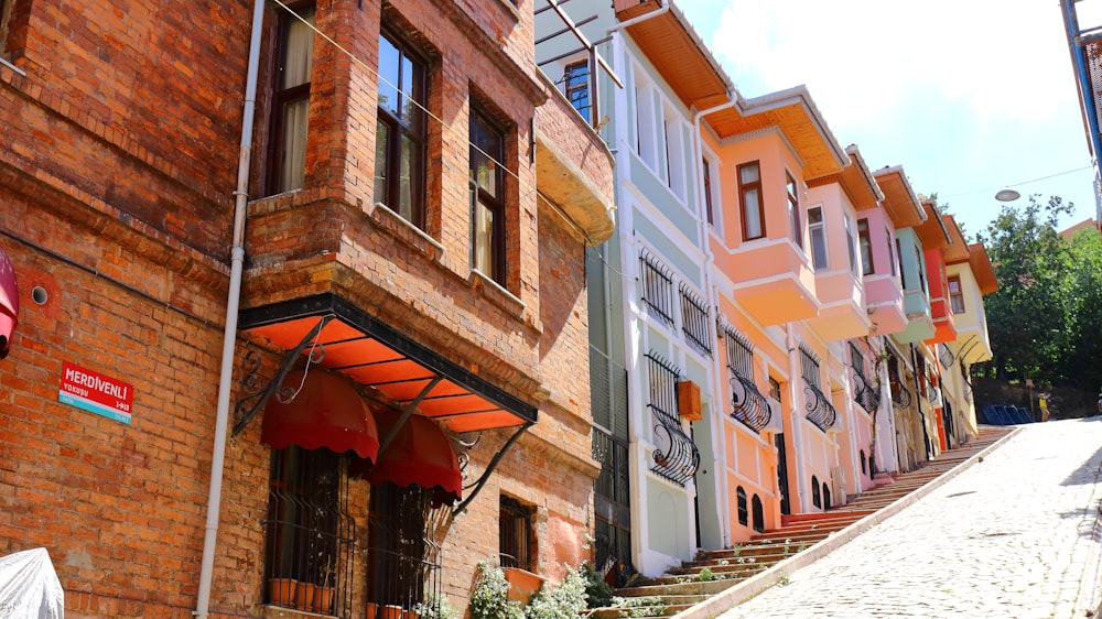 a row of multi - colored buildings on a cobblestone street