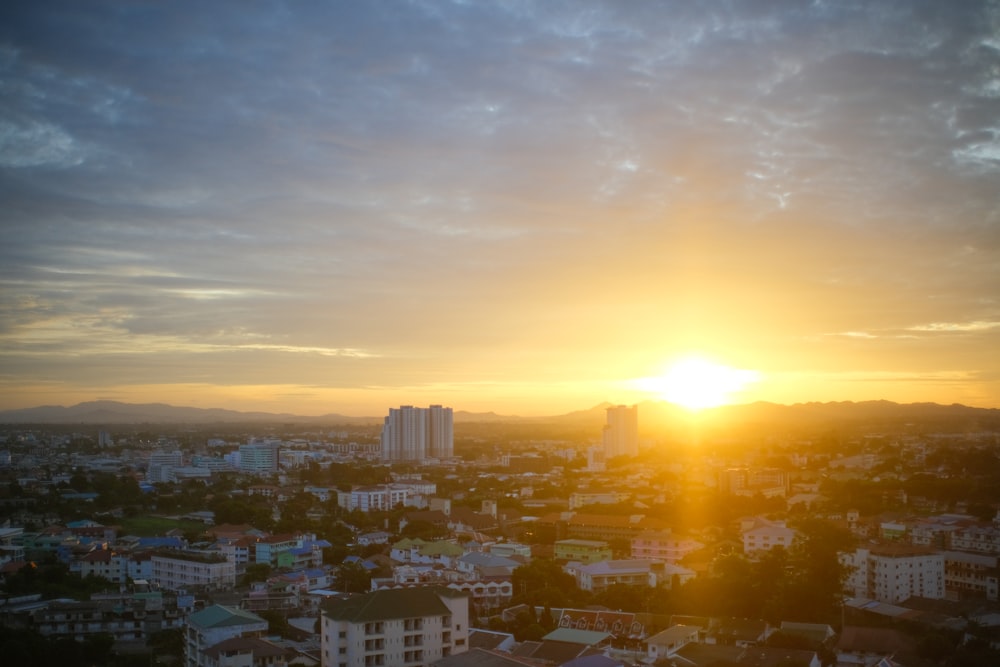 the sun is setting over a city with tall buildings