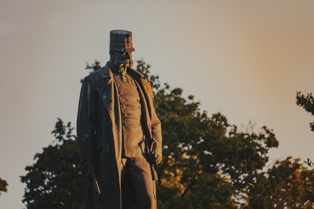 a statue of a man standing in front of trees