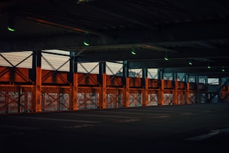 Wide shot of an industrial garage with dark steel walls and glowing orange accents.