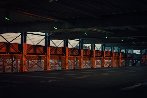 Wide shot of an industrial garage with dark steel walls and glowing orange accents.