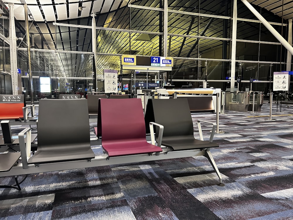 eine Reihe von Stühlen, die in einem Flughafen nebeneinander sitzen