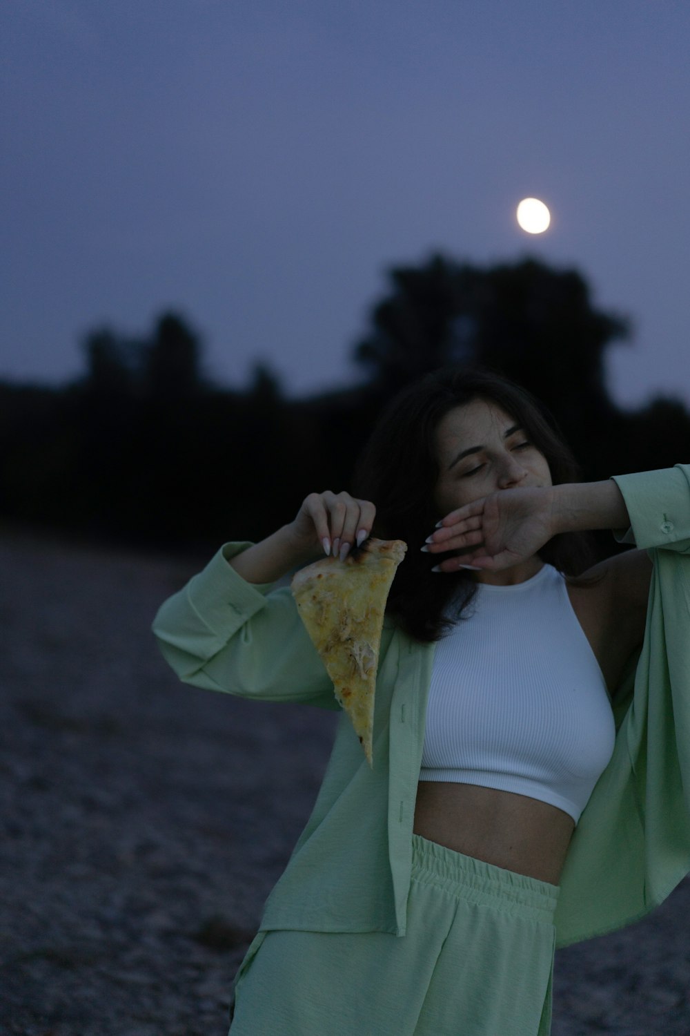 Una mujer con un top blanco y una chaqueta verde