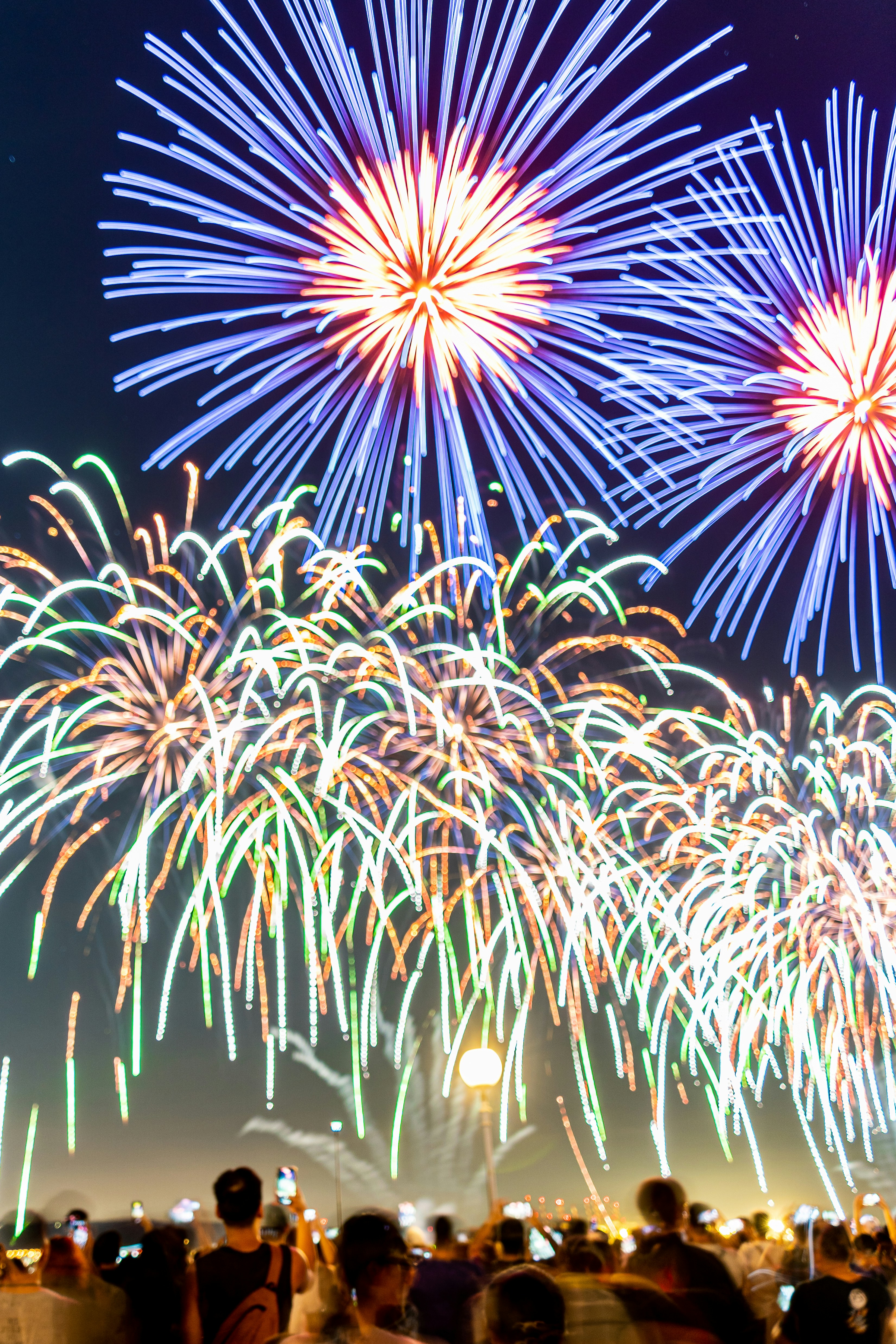 A group of people standing around a firework display photo – Free ...