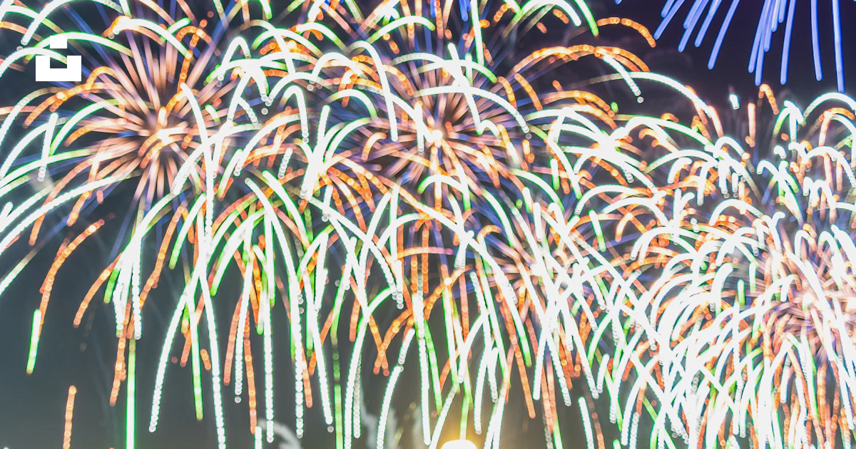 A group of people standing around a firework display photo – Free ...