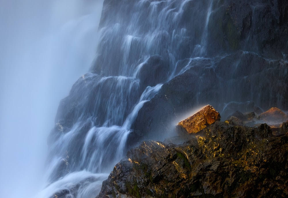 a waterfall with a rock in front of it