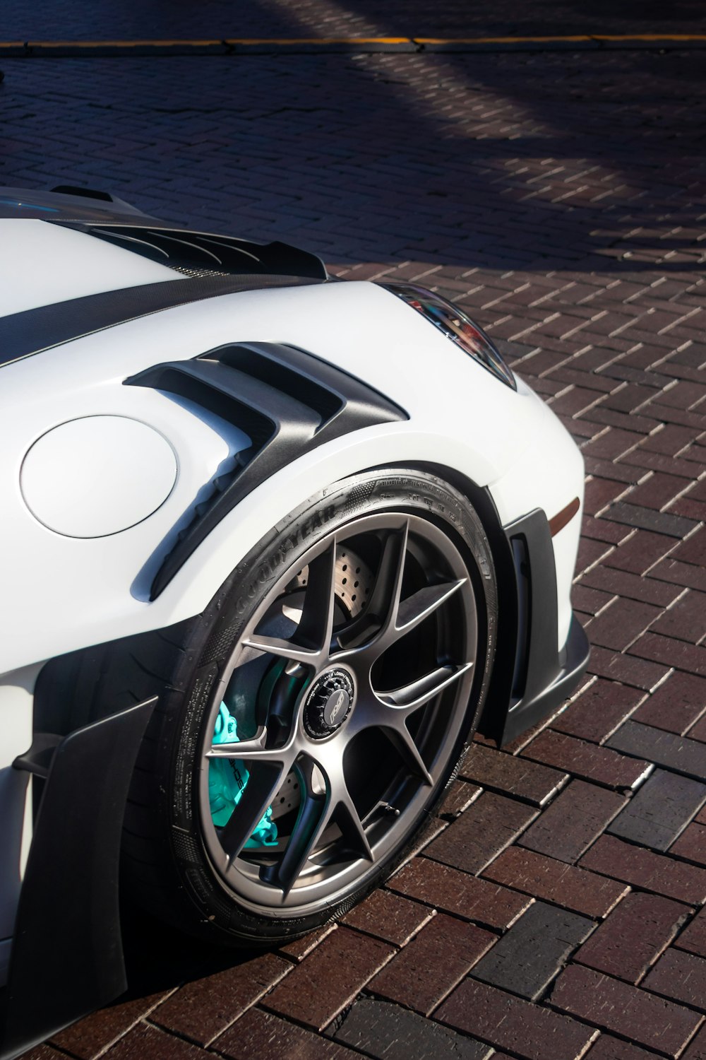a white sports car parked on a brick road