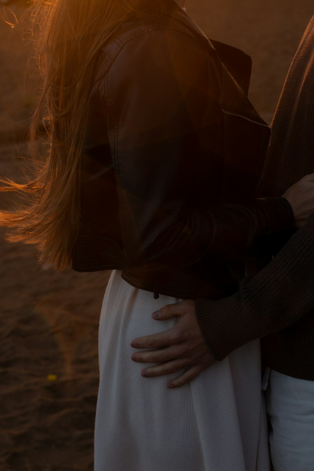 a man and a woman embracing on the beach