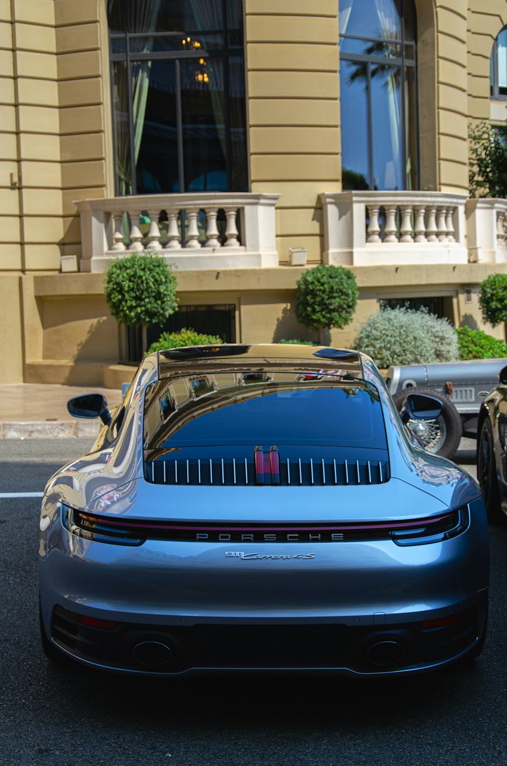 a blue porsche parked in front of a building