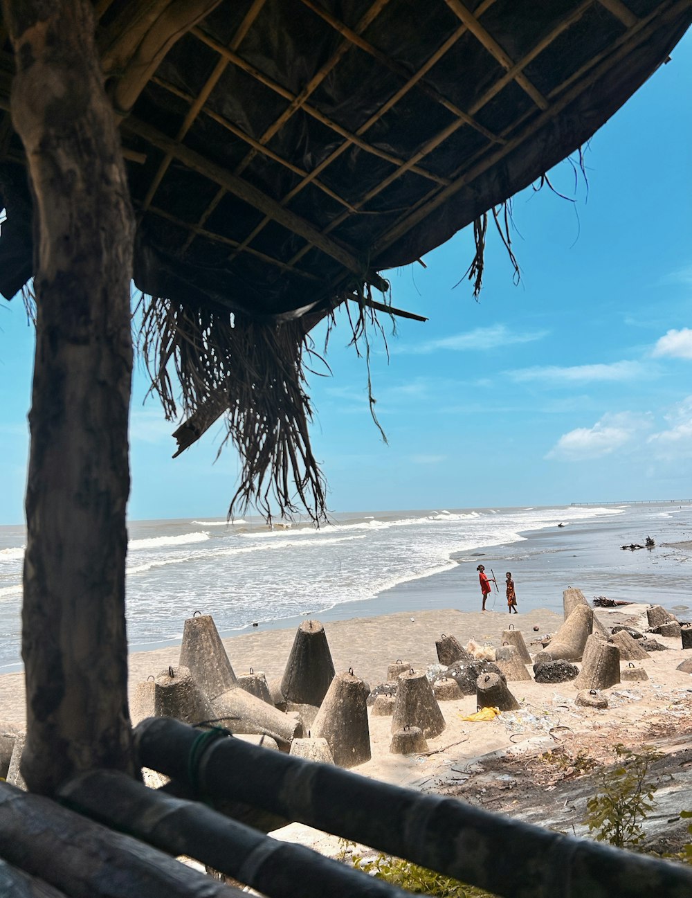 a view of a beach from a hut on a sunny day