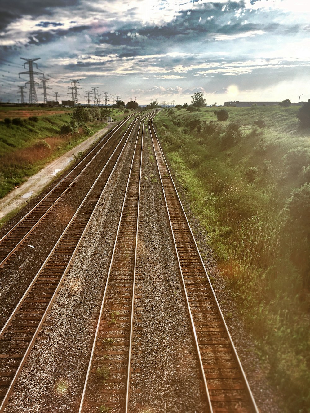 a train track running through a lush green countryside