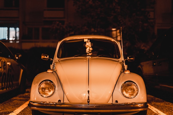 Classic Volkswagen Beetle shining under vintage neon lights at Duke's air cooled meet.