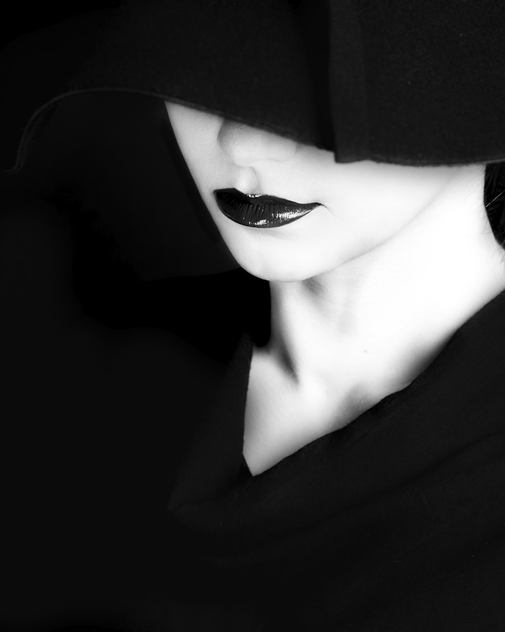 a woman wearing a black hat and black lipstick