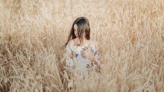 a woman standing in a field of tall grass