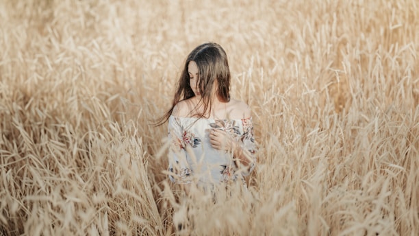 a woman standing in a field of tall grass