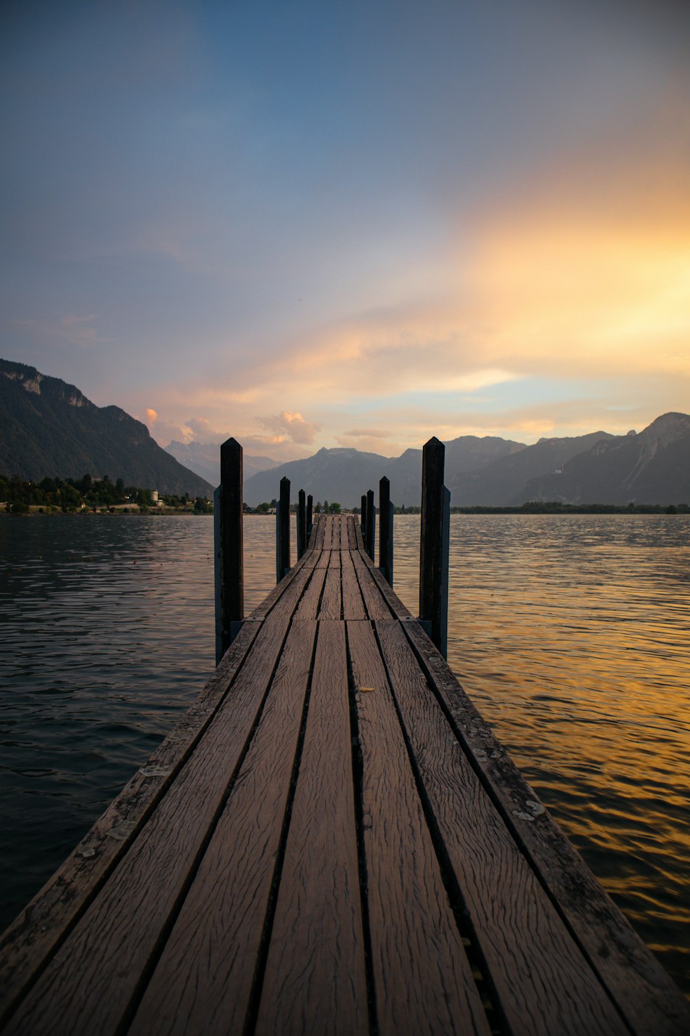 Un muelle de madera con montañas al fondo