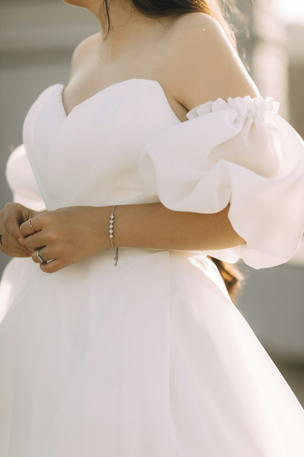 a woman in a white dress with a ring on her finger