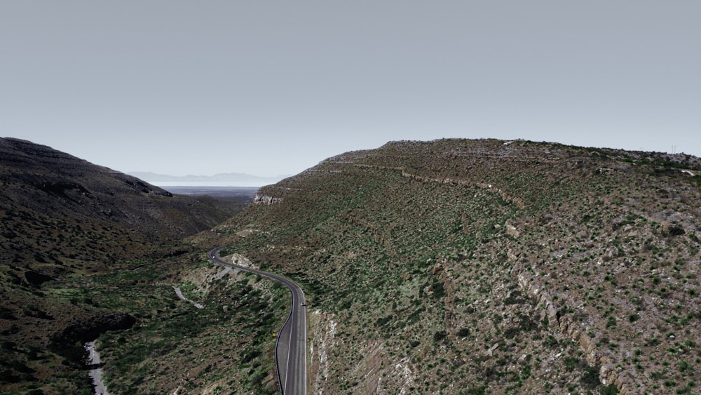 an aerial view of a winding road in the mountains