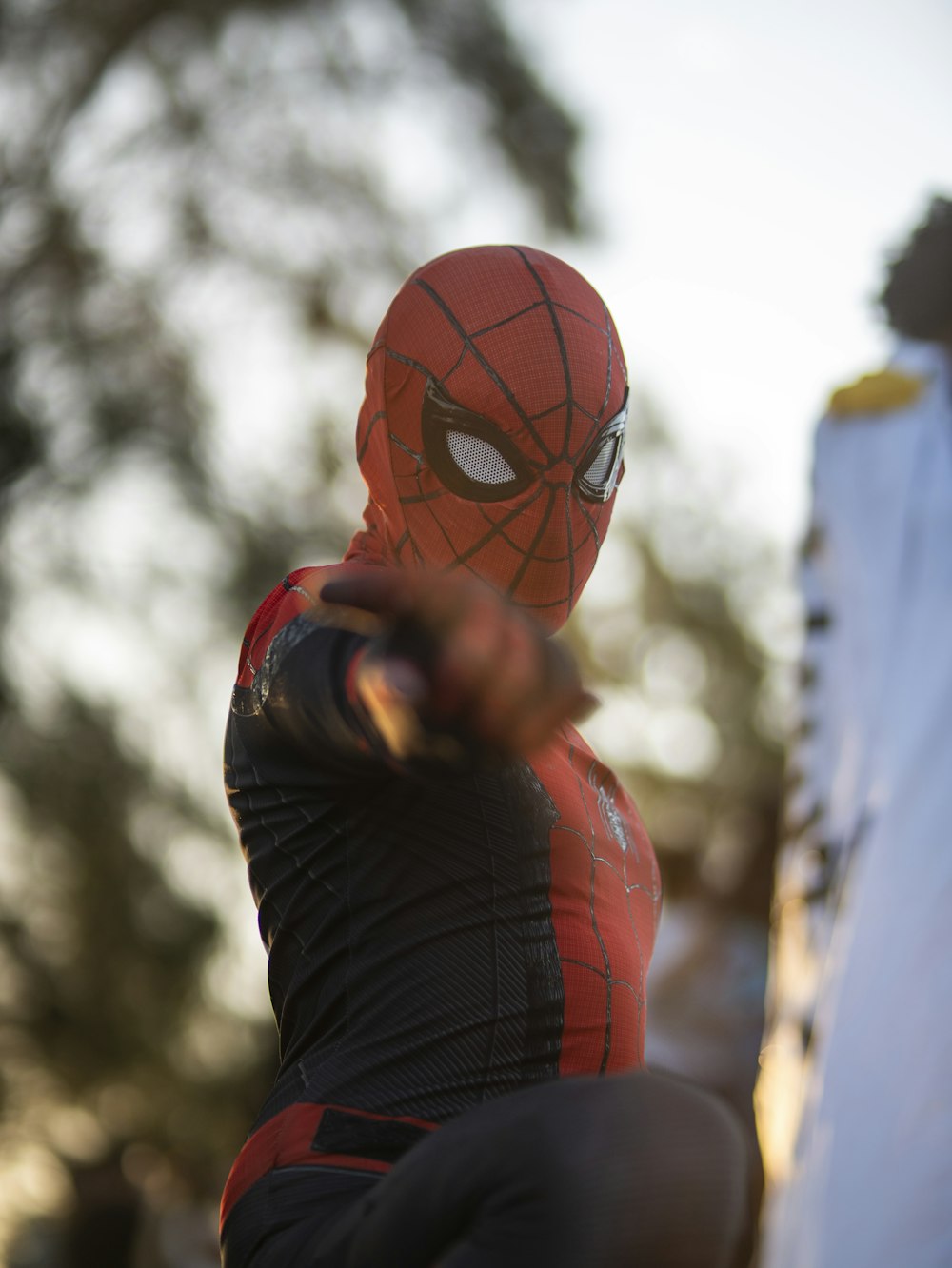 a man in a spider man costume holding a bat