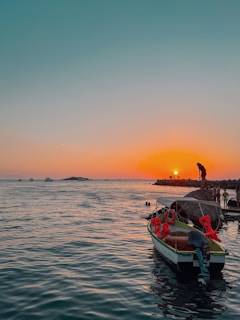 Sunset over the ocean with a Red Rose Marine vessel anchored, reflecting the calm and safety we ensure.