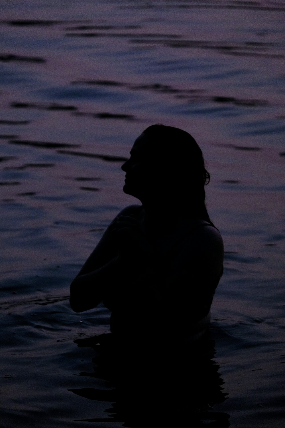 a person in a body of water at sunset