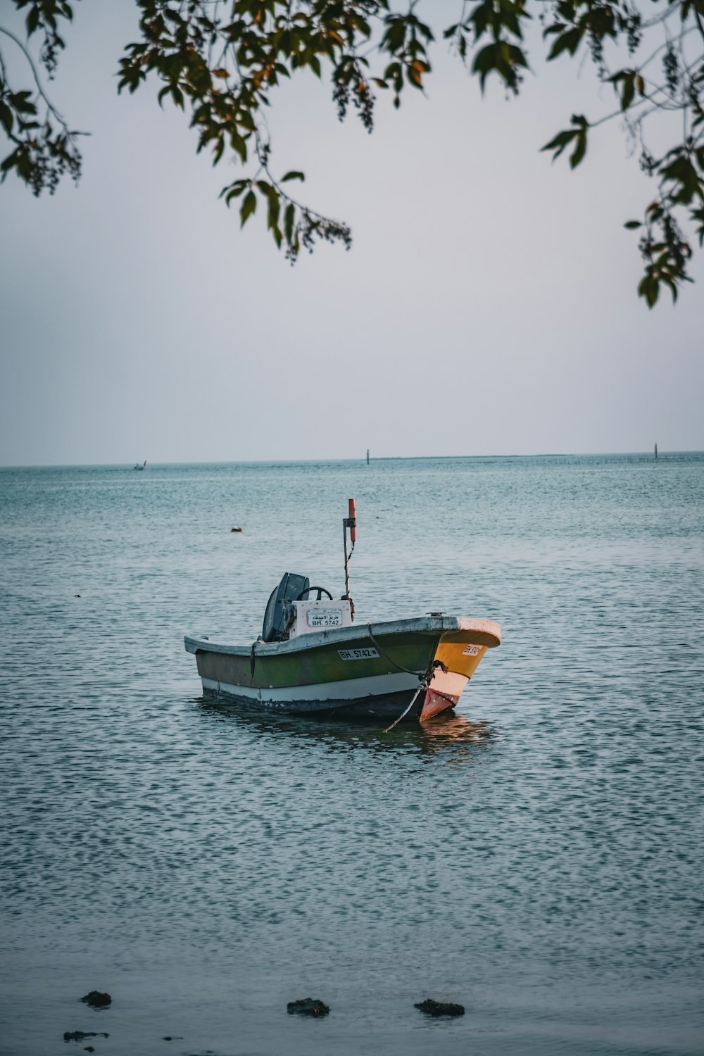 a small boat floating on top of a large body of water