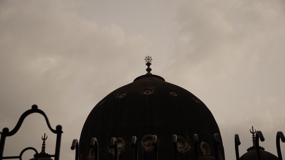 a black dome with a cross on top of it