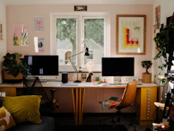 a desk with two computer monitors and a chair