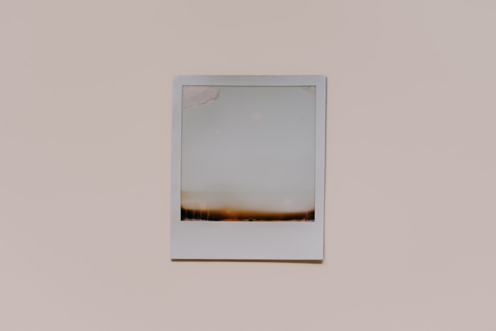 a white picture frame hanging on a wall