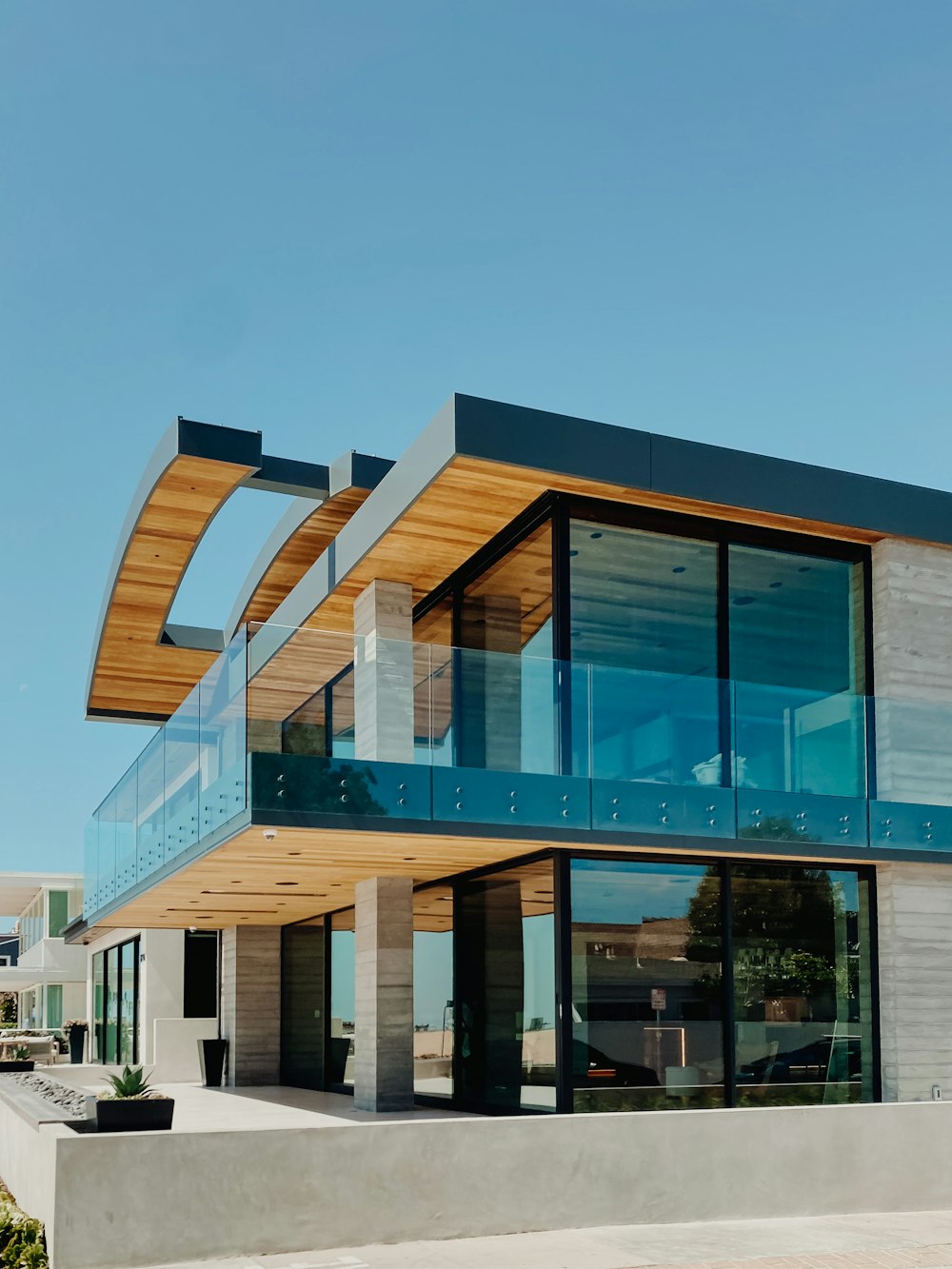 a modern house with a curved roof and glass walls