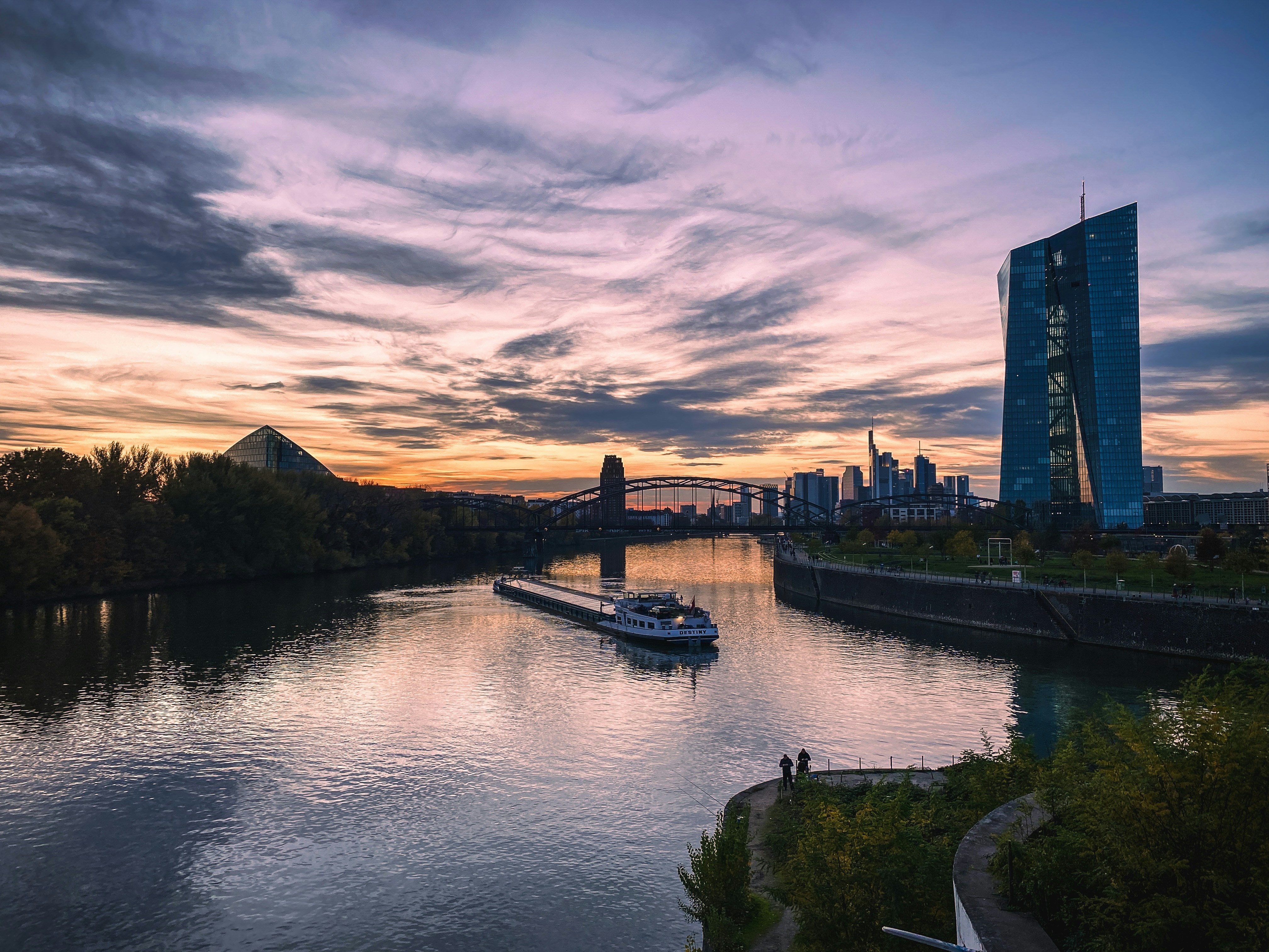 a boat traveling down a river next to a tall building