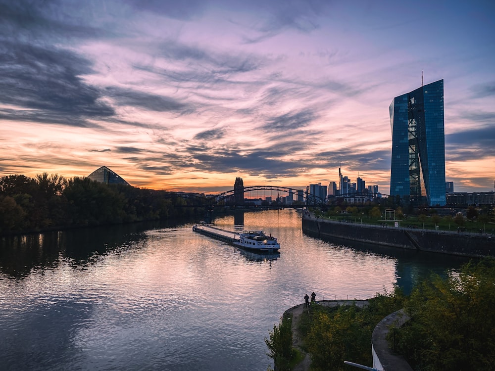 a boat traveling down a river next to a tall building