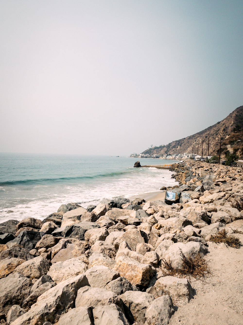 a rocky beach with a boat in the water