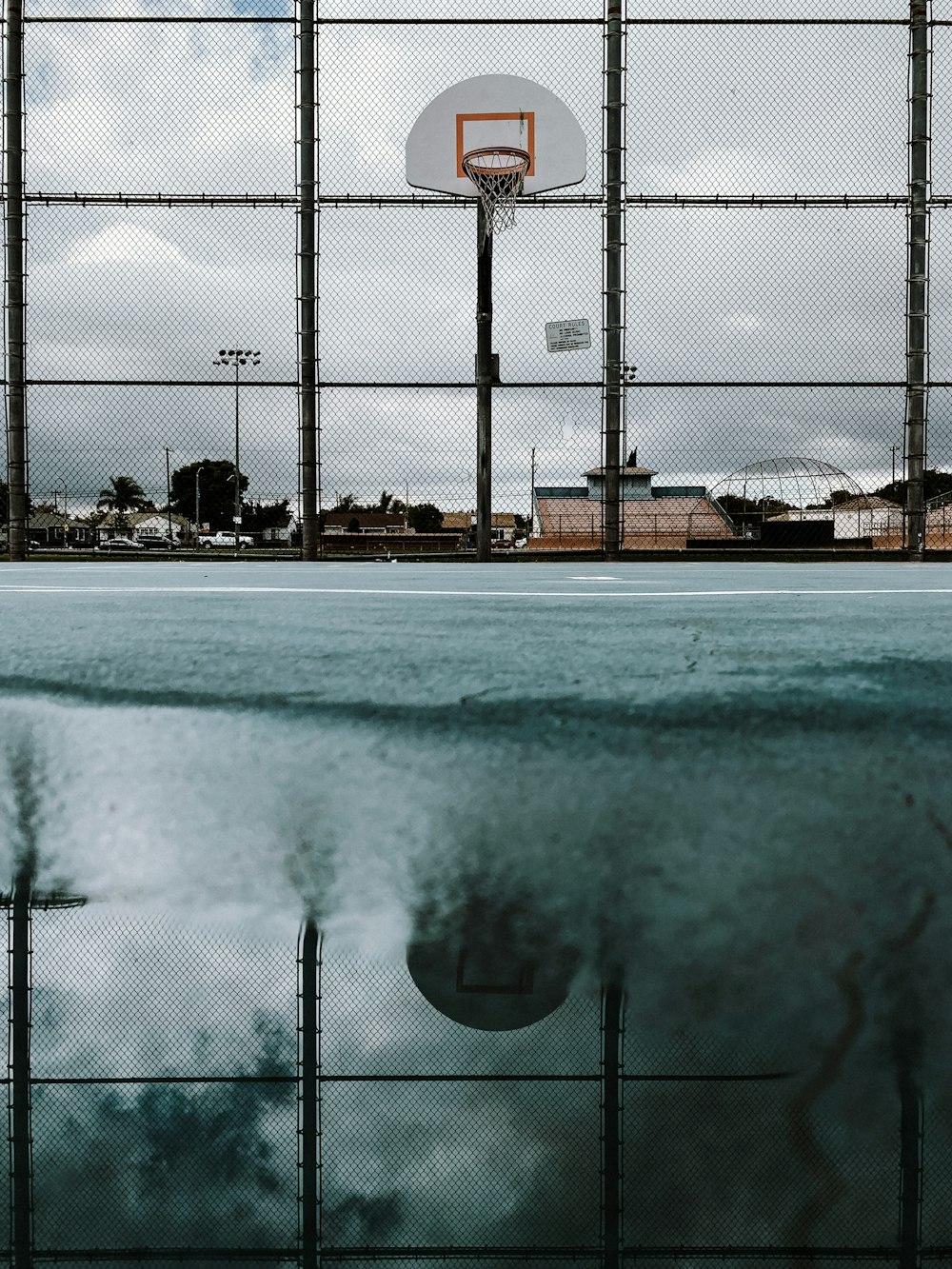 a reflection of a basketball hoop in a pool of water